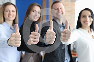 Group of business people showing thumbs up closeup