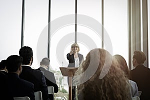 Group of business people sitting on conference together listening to the speaker giving a speech in the meeting room seminar  The