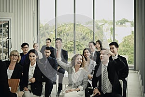 Group of business people sitting on conference together listening to the speaker giving a speech in the meeting room seminar