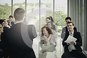 Group of business people sitting on conference together listening to the speaker giving a speech in the meeting room seminar  The