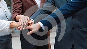 Group of business people stacking hands together to cheer up team spirit