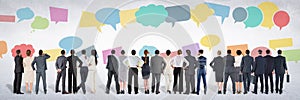 Group of business people standing in front of colorful chat bubbles