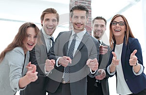 A group of business people standing and pointing at you