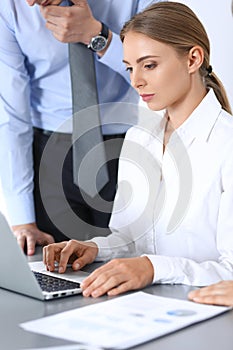 Group of business people using laptop computer in office. Meeting and teamwork concept