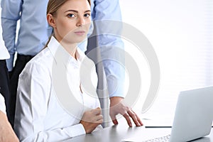 Group of business people using laptop computer while standing in office. Meeting and teamwork concept