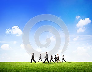 Group Of Business People Walking Through The Field In Daylight