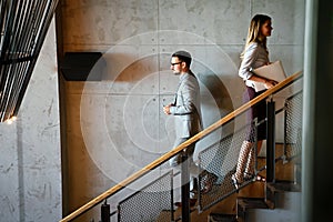 Group of business people walking and taking stairs in an office building