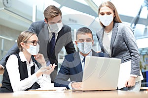 Group of business people wear preventive masks in epidemy are discussing corporate concept in office. photo