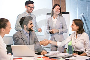 Group of business people welcoming young female colleague to their team.