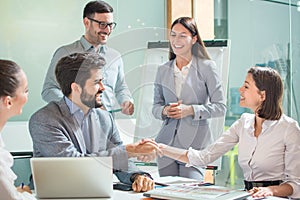 Group of business people welcoming young female colleague to their team.