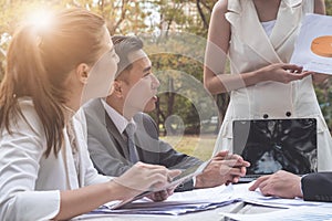 Group of business people working in team outdoors at park