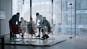 Group of business people working with technology at a meeting in a conference room