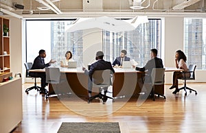 Group Of Business Professionals Meeting Around Table In Modern Office