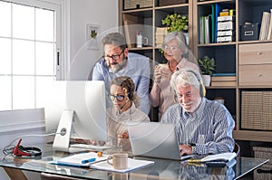 Group of business women and men working together with computer and laptop, sitting people wear headphones