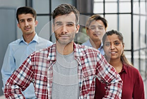 A group of business workers look seriously and confidently at the camera.