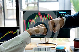 group businessman fist bump hand at the office table between computer laptop