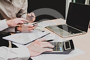 Group businessman hand using calculator on phone Calculating bonus to employees to increase productivity Writing paper on desk.