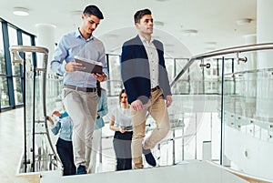 Businessmen and businesswomen walking and taking stairs in an office building