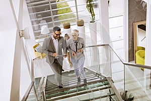 Businessmen and businesswomen walking and taking stairs in an of