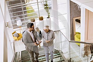 Businessmen and businesswomen walking and taking stairs in an of