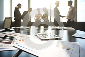 A group of businessmen discussing at sunset reflects on a table with documents