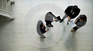 A group of businessmen discussing work in the hall of a modern office. People corporate business team concept. Top View