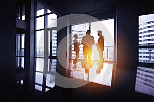 Group businessmen silhouettes three office big window concept