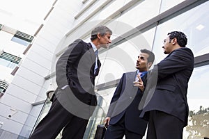 Group of businessmen talking outside office buildi photo