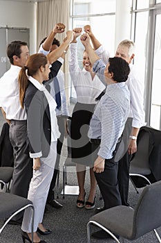 Group Of Businesspeople With Arms Raised At Company Seminar