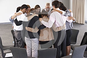 Group Of Businesspeople Bonding In Circle At Company Seminar