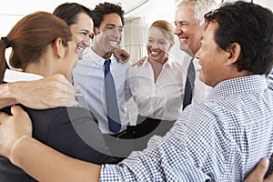 Group Of Businesspeople Bonding In Circle At Company Seminar