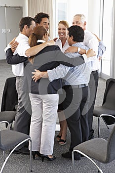 Group Of Businesspeople Bonding In Circle At Company Seminar