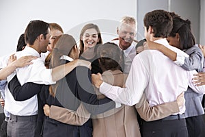 Group Of Businesspeople Bonding In Circle At Company Seminar