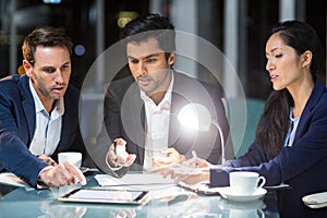 Group of businesspeople discussing over digital tablet