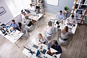 Group Of Businesspeople Discussing While Working In Office