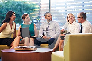 Group Of Businesspeople Having Meeting In Office Lobby