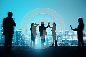 Group of businesspeople with hi-five gesture standing on night city sky with mock up place background. Success, teamwork and