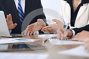 Group of businesspeople or lawyers discussing contract papers and financial figures while sitting at the table. Close-up