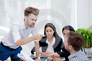 Group of businesspeople looking at businessman blaming his colleague.