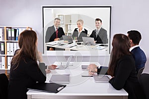 Group Of Businesspeople Looking At Projector