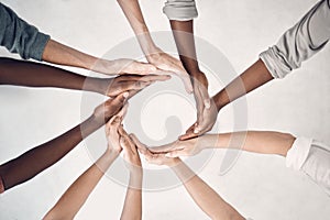 Group of businesspeople making a circle shape with their hands together in an office at work. Business professionals