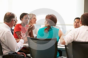 Group Of Businesspeople Meeting Around Boardroom Table