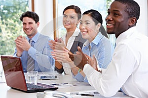 Group Of Businesspeople Meeting Around Boardroom Table