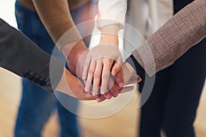 Group of businesspeople putting their hands on top of each other