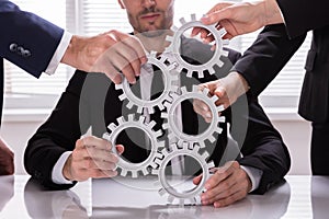 Group Of Businesspeople Stacking Gears
