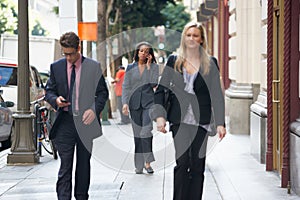 Group Of Businesspeople Walking Along Street