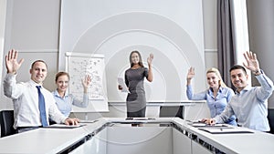 Group of businesspeople waving hands in office
