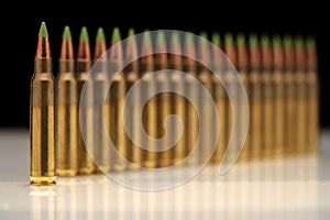 A group of 5.56 calibar, green tip bullets ordered into the line on black background photo