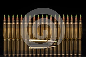 A group of 5.56 calibar, green tip bullets ordered into the line on black background photo