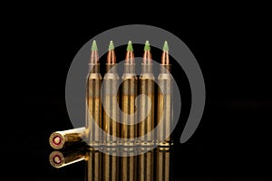 A group of 5.56 calibar, green tip bullets ordered into the line photo
